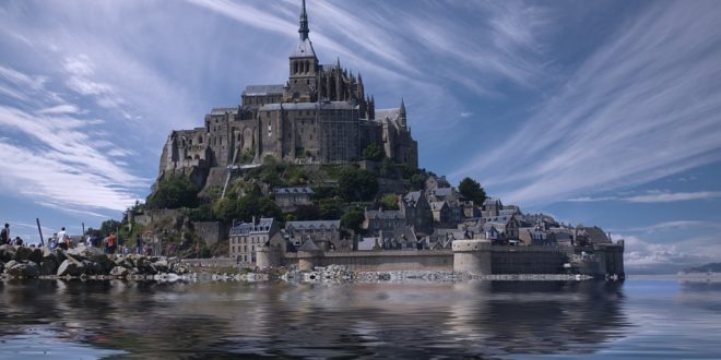 Mont-Saint-Michel in Normandia con la baia e l'abbazia medievale riflessa nell'acqua durante la bassa marea